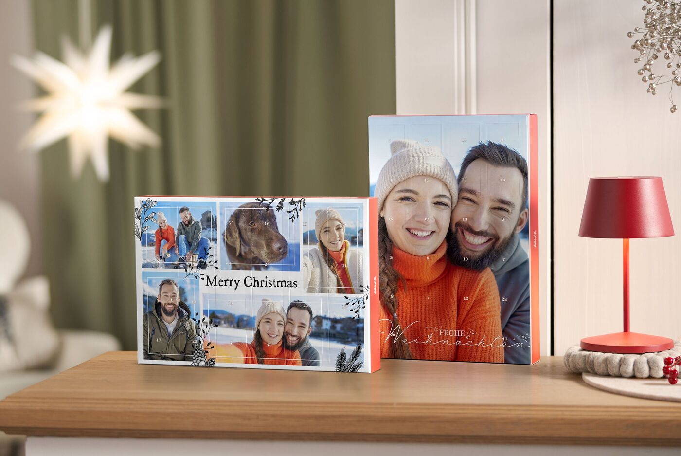 Zwei CEWE Fotobücher mit fröhlichen Urlaubsfotos und einem Weihnachtsgruß auf einem Tisch.